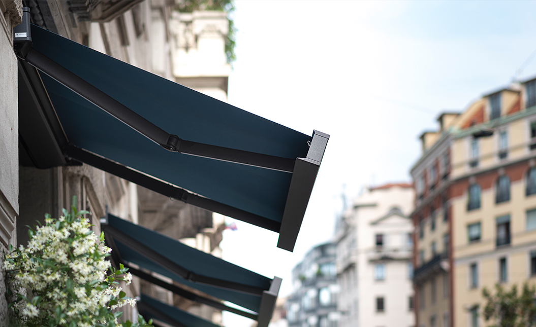 Commercial retractable awnings providing shade and weather protection across business storefront and windows