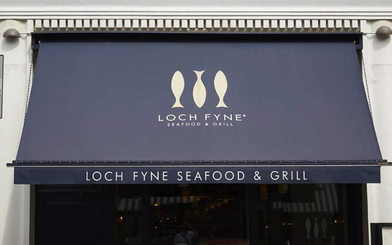 Branded retractable commercial awning with company logo enhancing business visibility and curb appeal